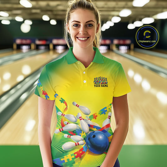 Female model inside a bowling center wearing green and yellow polo shirt, front view with autism puzzle bowling ball and pins design
