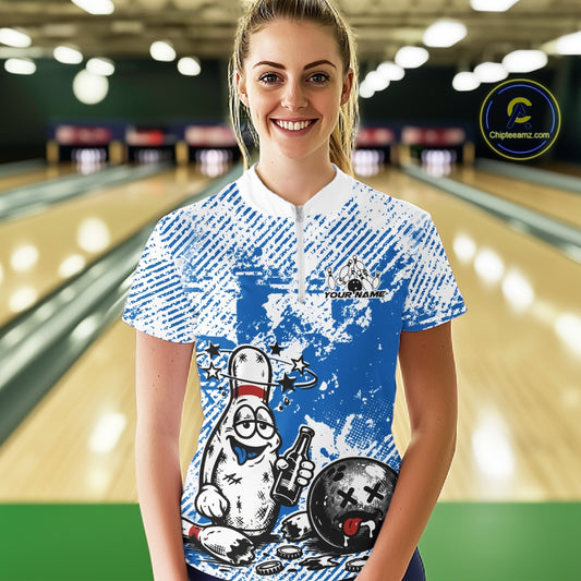 Front view female model in blue and white quarter zip bowling shirt in bowling lane, cartoon bowling pin drinking beer and holding ball graphic