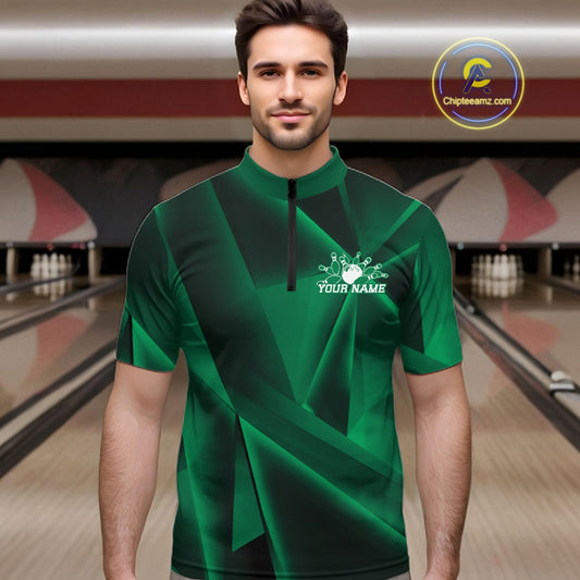 Man wearing a green bowling shirt with a logo and text in a bowling alley.