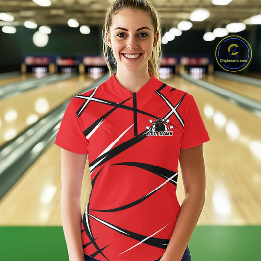 Front view of a female bowler in a bowling alley wearing a red, black, and white bowling quarter-zip shirt with an athletic jersey pattern