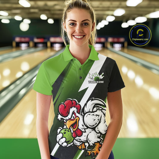 A woman stands in a bowling alley wearing a custom-designed athletic polo shirt with a green and black color-blocked design, a white diagonal stripe, and a cartoon rooster mascot graphic on the front. The background shows blurred bowling lanes.