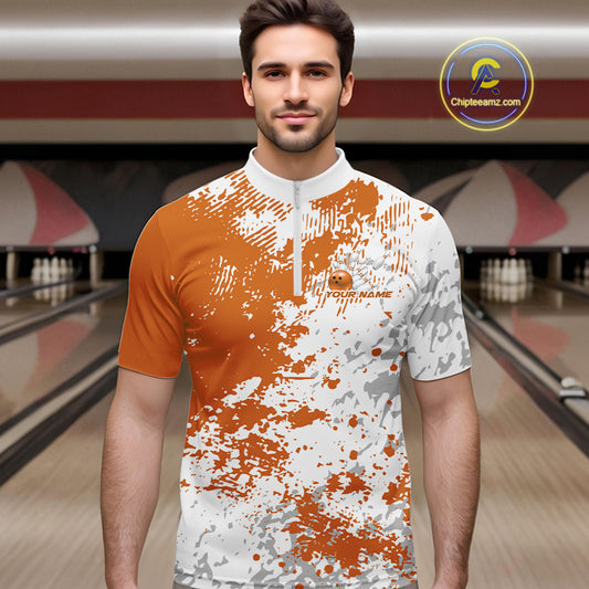Male model in a bowling lane wearing orange and white quarter zip shirt, front view showcasing orange splatter pattern with simple abstract sportswear styling
