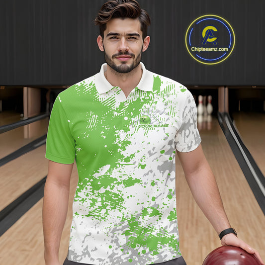 Front view of a male model in a bowling lane wearing a green and white splatter polo shirt with minimalist bowling-themed design accents.