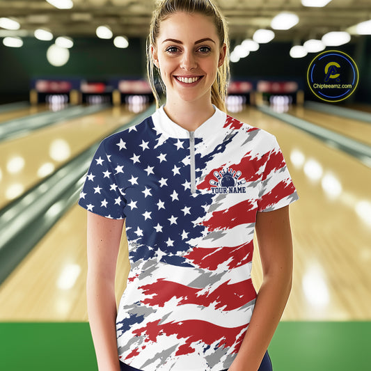 Person wearing a custom American flag shirt with a logo and text in a bowling alley.