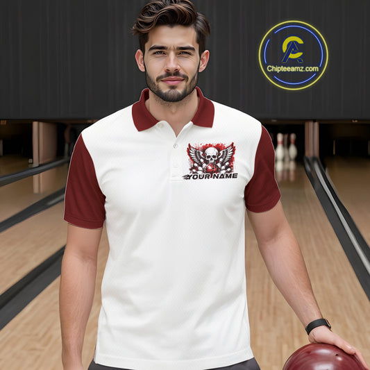 A man stands in a bowling alley wearing a bowling shirt with polo collar, red skull-themed bowling graphic with black wings, pins, bowling ball