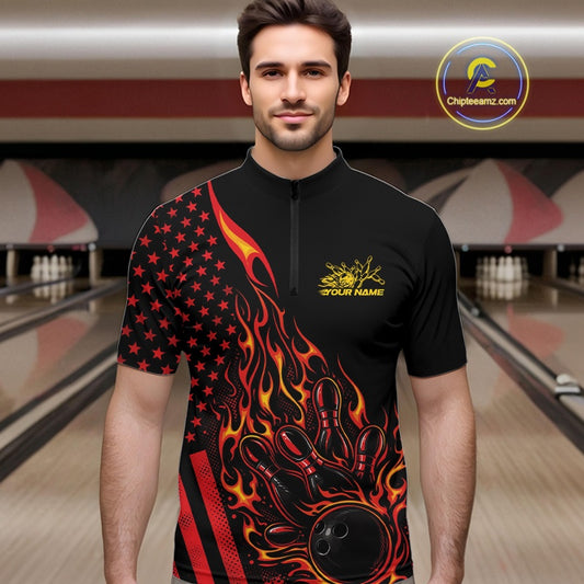 Male model at a bowling lane wearing a black bowling quarter-zip shirt with a red and orange flaming bowling ball striking pins and patriotic American flag artwork.