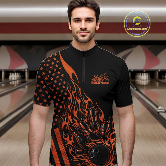 Male model at a bowling lane wearing a black bowling quarter-zip shirt with orange flame bowling strike artwork and patriotic graphics.