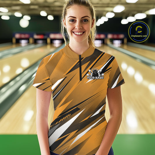 Woman wearing a yellow and black bowling shirt with a logo in a bowling alley.