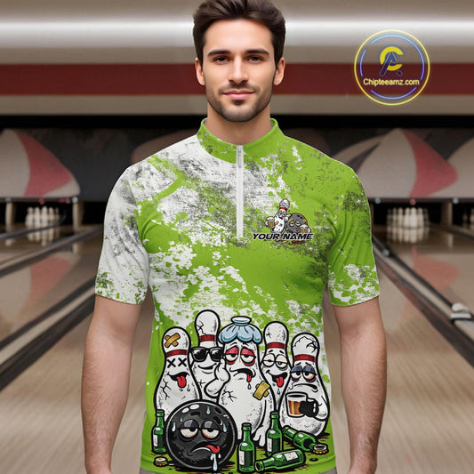 Male model in a bowling lane wearing green and white quarter zip shirt, front view featuring grunge splatter design with cartoon bowling pins and beer bottle accents