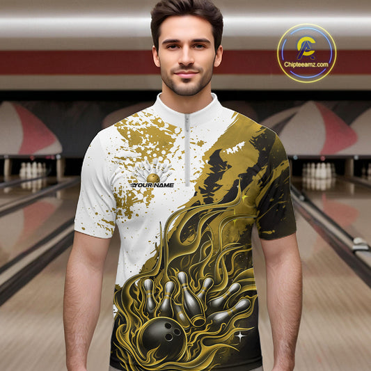 Front view of a male model in a bowling lane wearing a black quarter-zip shirt with black, yellow and white flame bowling ball and pins artwork and energetic bowling visuals.