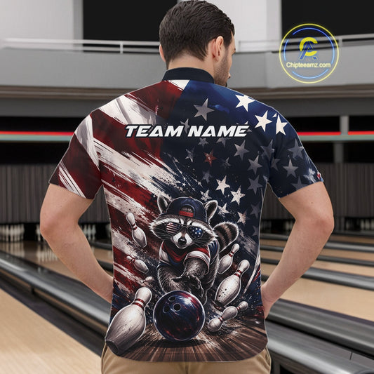 Front view of a male model at a bowling lane wearing a bowling quarter-zip shirt with a raccoon in patriotic sunglasses rolling a bowling ball through scattered pins and a distressed American flag backdrop.