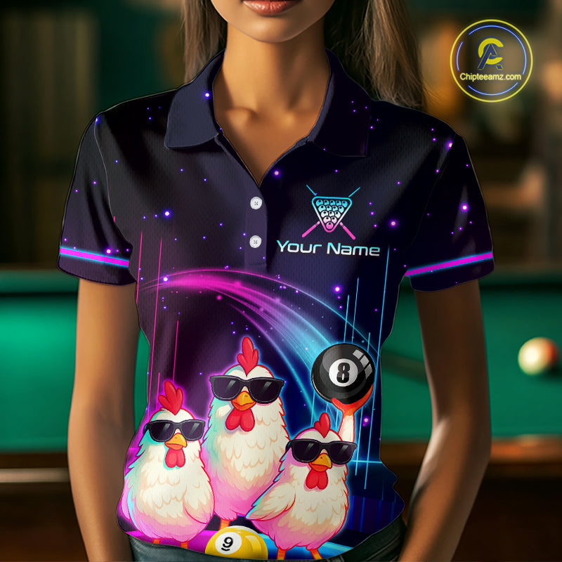 A woman wearing a dark navy polo shirt with a neon gaming and poultry theme. The shirt features three cartoon chickens wearing black sunglasses, a 8-ball pool cue, and a purple starry space background.
