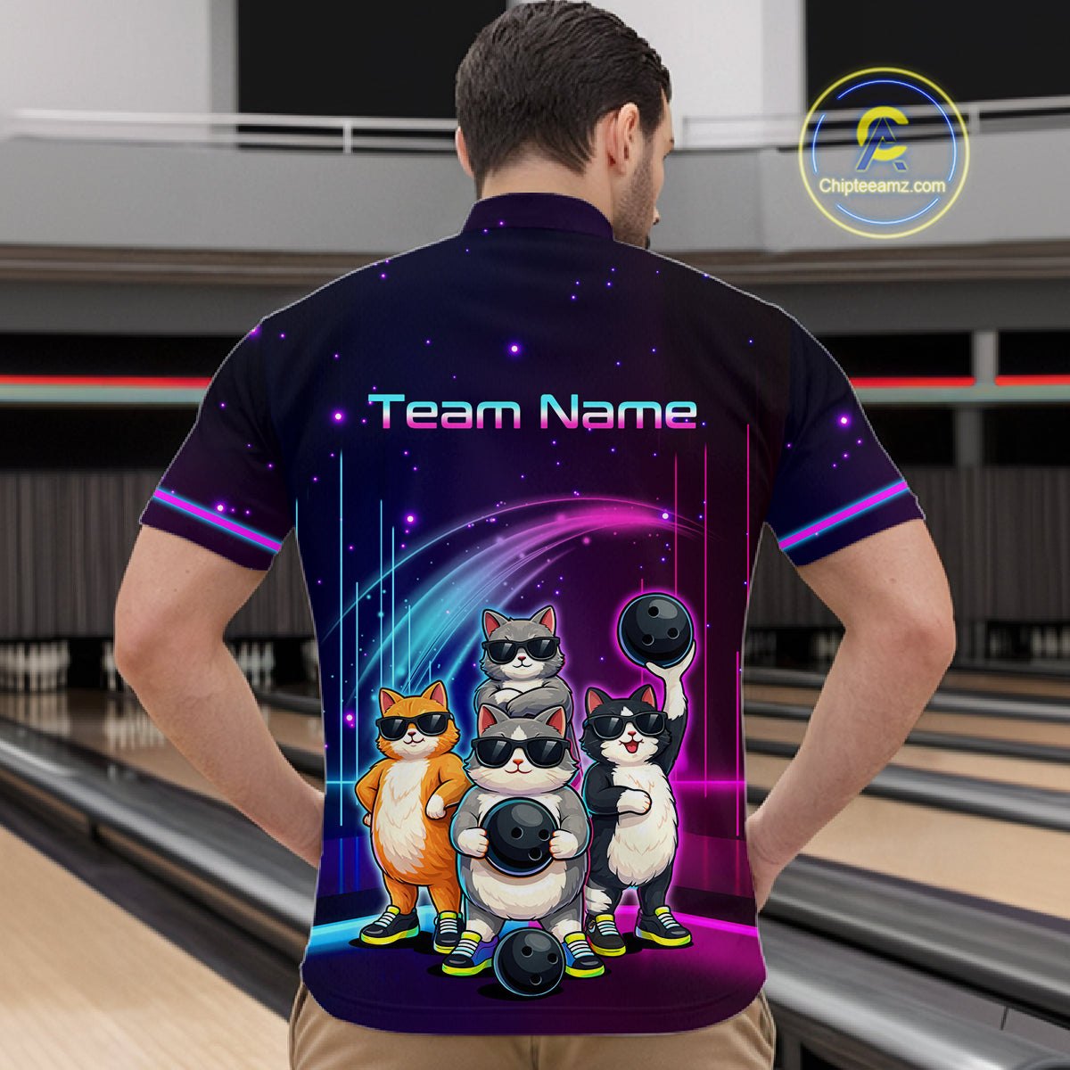Person wearing a bowling shirt with cartoon cats and 'Team Name' text in a bowling alley.