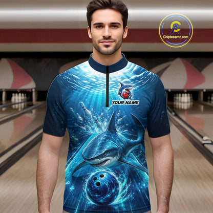Man wearing a blue and black bowling shirt with shark design in a bowling alley.