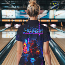 Load image into Gallery viewer, A woman viewed from behind wearing a dark navy short-sleeve shirt with a large colorful bowling-themed graphic on the back and the text 'TEAM NAME' across the shoulders. The background shows a blurred bowling alley with lanes and pins.