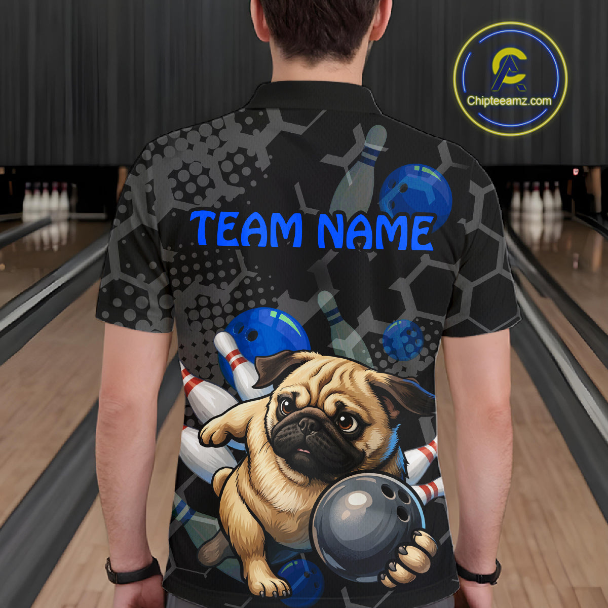 Person wearing a bowling-themed shirt with a pug holding a bowling ball in a bowling alley.