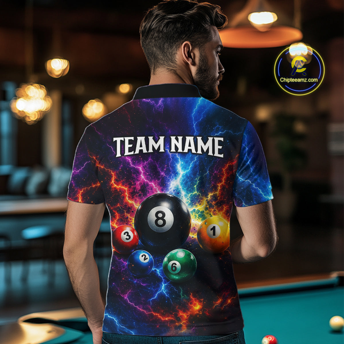 Person wearing a colorful billiard ball-themed shirt with 'TEAM NAME' text, standing in a pool hall.