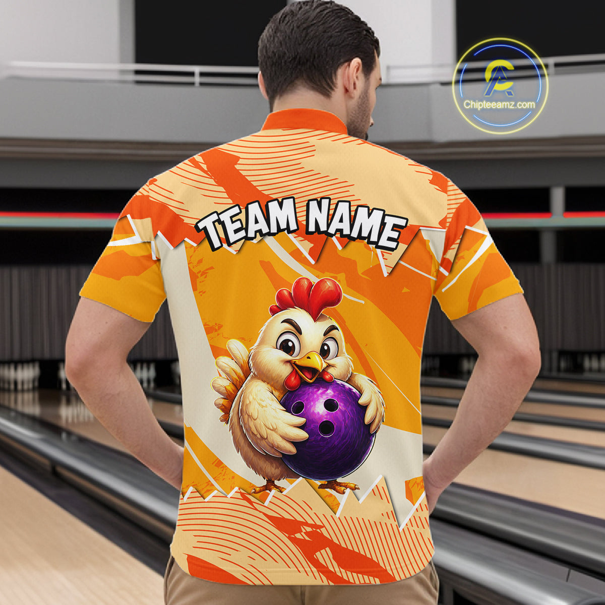 Person wearing a bowling shirt with a chicken holding a bowling ball design in a bowling alley.