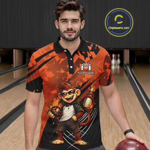 Load image into Gallery viewer, A man wearing a custom printed short-sleeve polo shirt in a bowling alley setting. The shirt features a bold orange and black graphic design with a cartoon monkey character holding bowling balls and the text 'YOUR NAME' on the chest.