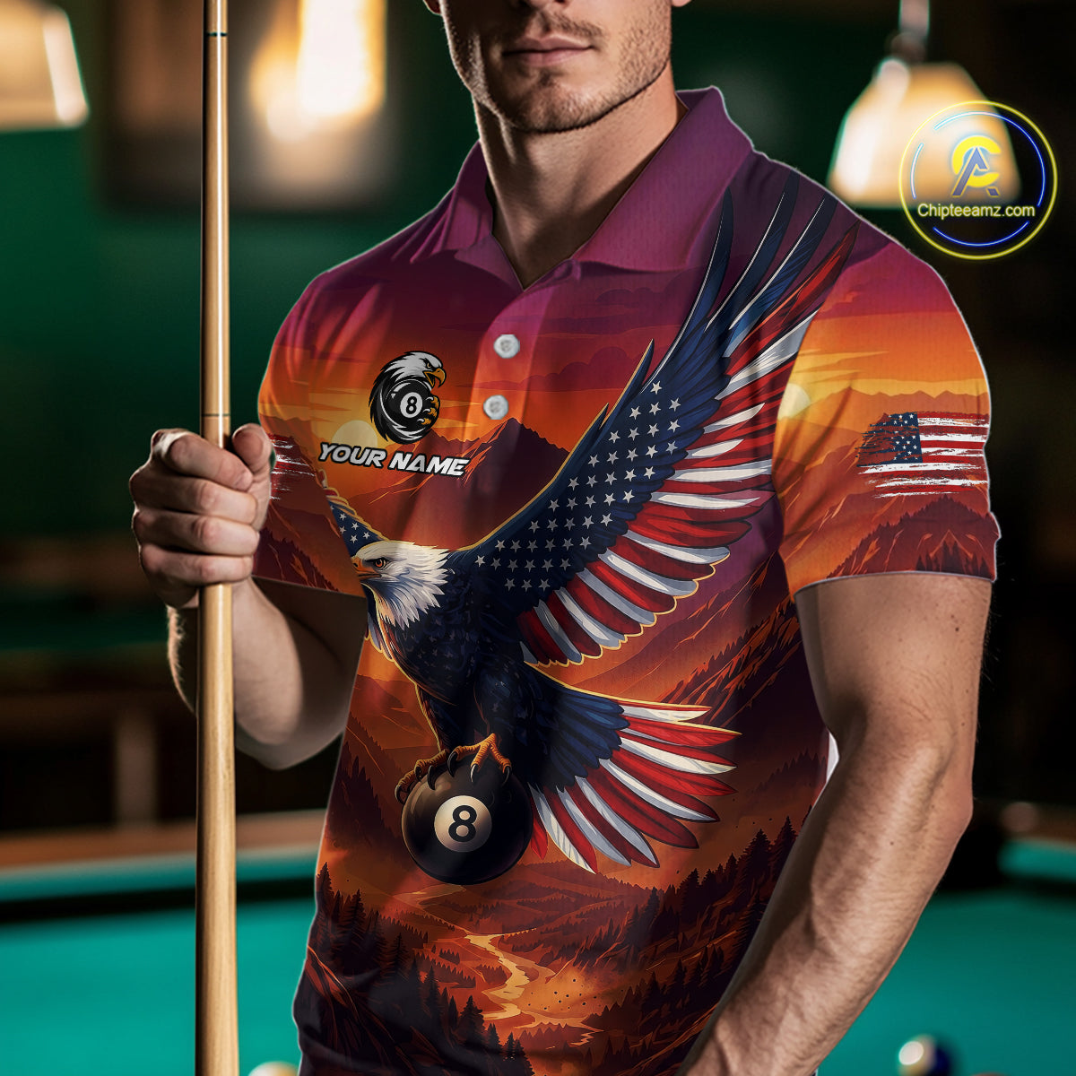 Man wearing a colorful polo shirt with an eagle design and pool cue in front of a pool table.