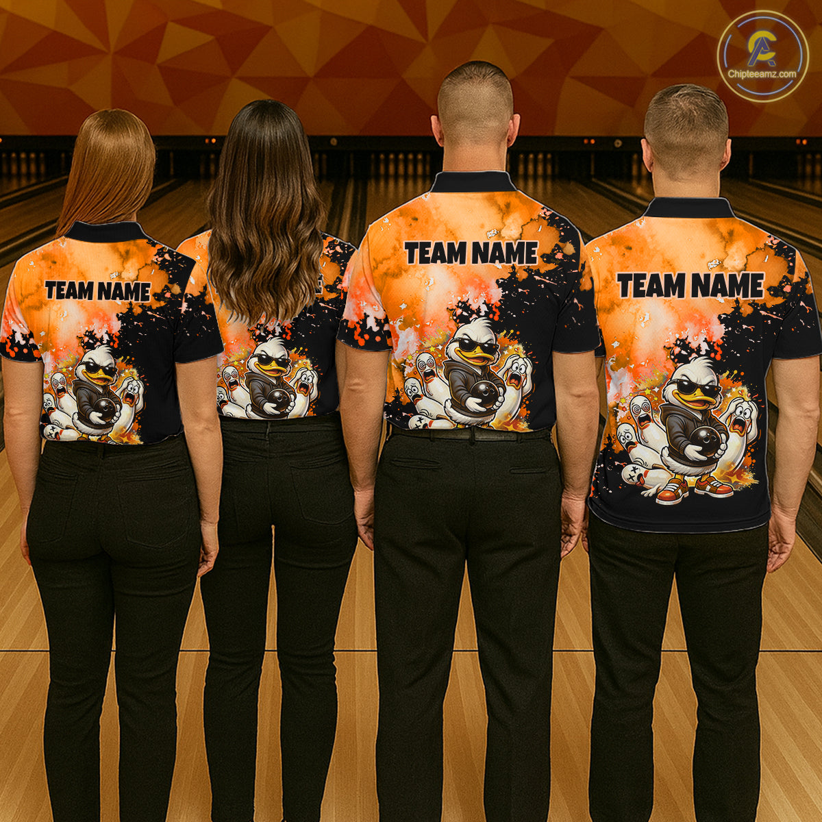 Four people standing with their backs to the camera in a bowling alley, wearing matching bowling shirts with a black and orange flame design, cartoon bowling balls, and 'TEAM NAME' printed on the back.