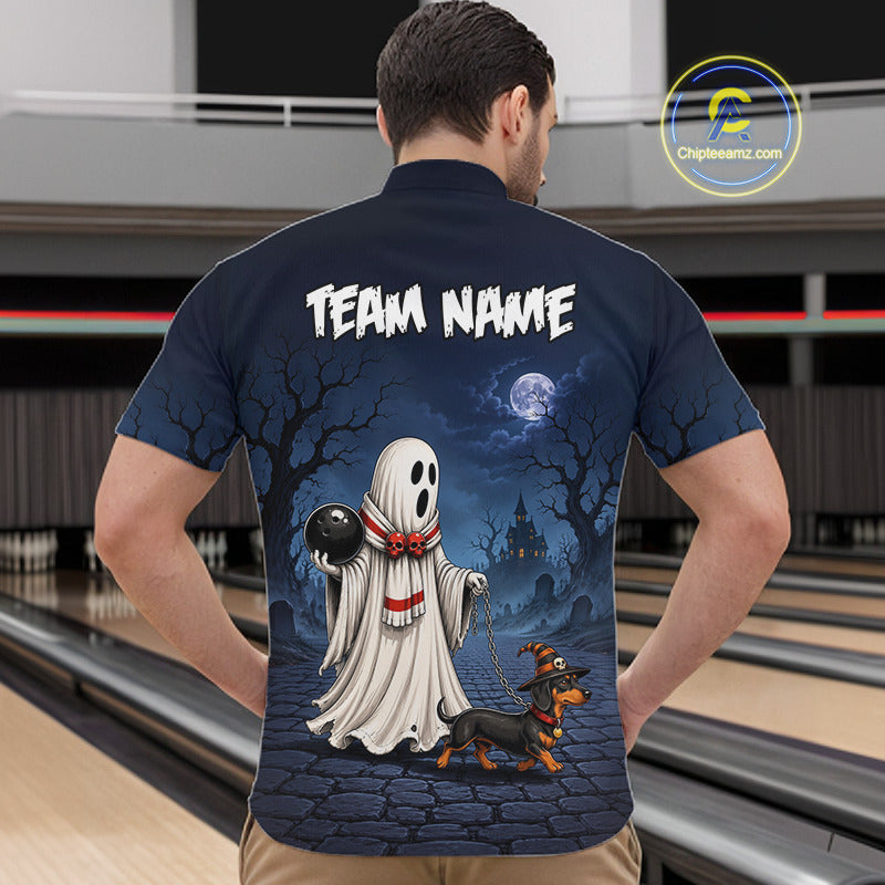 A man viewed from behind wearing a navy blue bowling shirt with a large Halloween graphic on the back. The graphic features a white ghost holding a black bowling ball, a dachshund, a haunted house under a full moon, and the text 'TEAM NAME'.