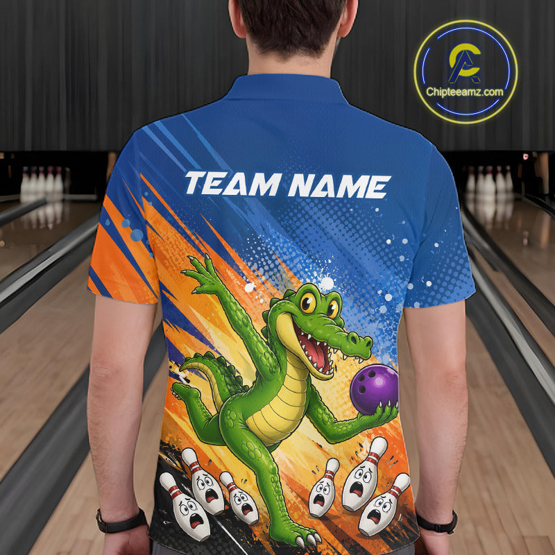 A person viewed from behind wearing a short-sleeve bowling-themed shirt with a large green alligator graphic holding a purple bowling ball, orange and blue background graphics, and the text 'TEAM NAME' across the upper back. Bowling lanes are visible in the background