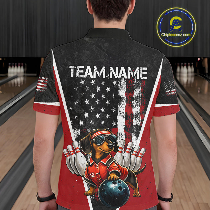 A person viewed from behind wearing a short-sleeve bowling-themed graphic shirt in a bowling alley. The shirt has a black and red design with an American flag motif