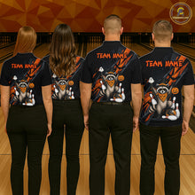 Load image into Gallery viewer, Four people wearing black Halloween bowling polo featuring a raccoon wearing an orange bandana, ghost and pumpkin accents, bowling pins and ball, with personalized name and team name text.