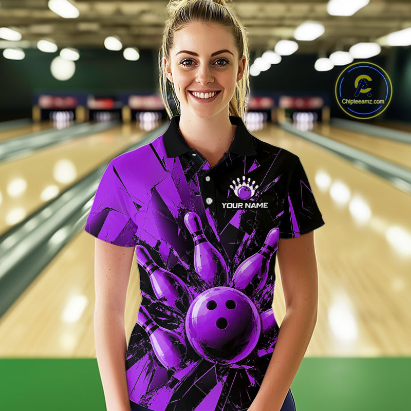 A woman stands in a bowling alley wearing a short-sleeve polo shirt with a bold purple and black bowling-themed graphic print featuring bowling pins and a bowling ball. The shirt has a black collar and sleeve trim, with a white placeholder logo on the chest that reads 'YOUR NAME'.