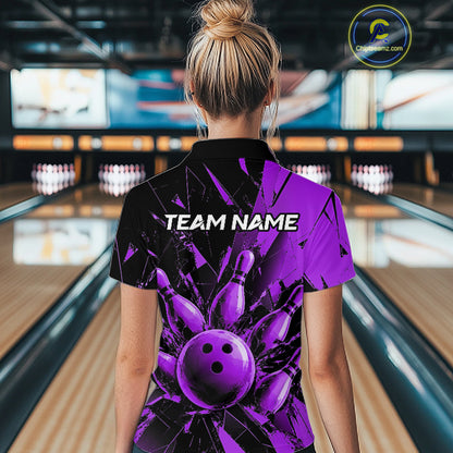 A woman viewed from behind wearing a short-sleeve bowling-themed polo shirt with a black and purple graphic design featuring a bowling ball and pins, set in a bowling alley.