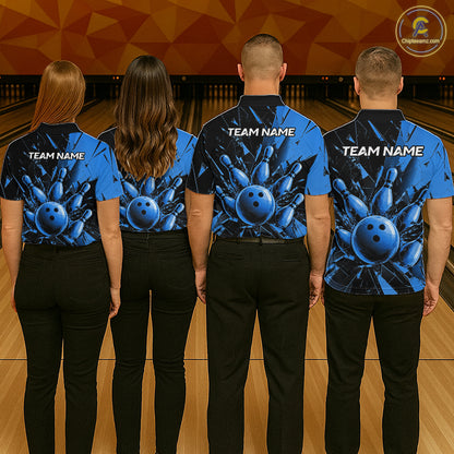 Four people standing in a bowling alley, viewed from behind, wearing matching blue bowling-themed short-sleeve shirts with black pants. The shirts feature a large blue bowling ball and pins graphic on the back with 'TEAM NAME' printed in white.