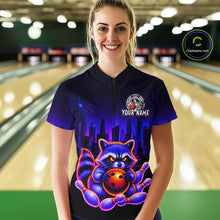 Load image into Gallery viewer, Women wearing bowling quarter zip shirt featuring a raccoon holding a bowling ball framed by pins with purple city skyline background.