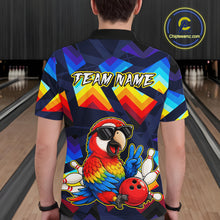 Load image into Gallery viewer, A person viewed from behind wearing a short-sleeve bowling-themed graphic shirt in a bowling alley. The shirt features a colorful parrot, bowling pins, a bowling ball, and the text 'TEAM NAME' on the back.