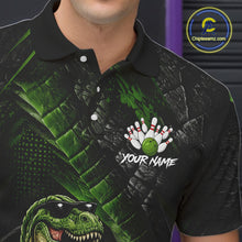 Load image into Gallery viewer, Bowling polo shirt featuring a dinosaur standing among bowling pins and ball artwork on black green textured background.