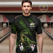 Load image into Gallery viewer, Man wearing bowling quarter zip shirt featuring a dinosaur standing among bowling pins and ball artwork on black green textured background.
