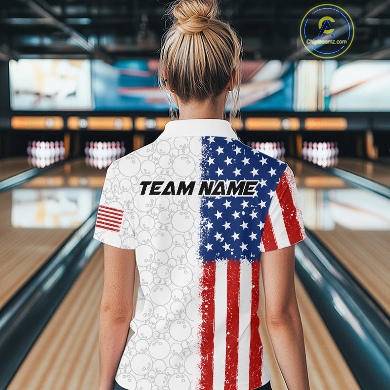 A woman viewed from behind wearing a custom short-sleeve bowling shirt with an American flag design on a bowling alley background. The shirt features a distressed red, white, and blue flag pattern on the back, with 'TEAM NAME' printed across the center.