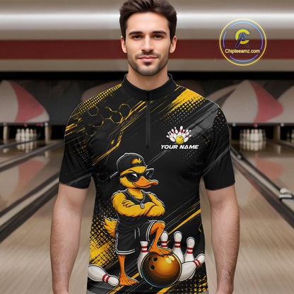 Man wearing a black and yellow bowling shirt with a duck design in a bowling alley.