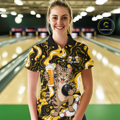 A woman stands in a bowling alley wearing a short-sleeve polo shirt with a bold black and yellow abstract pattern and a large graphic of a cartoon cat holding a bowling ball and beer glass. The shirt also has a 'YOUR NAME' customization area on the chest.