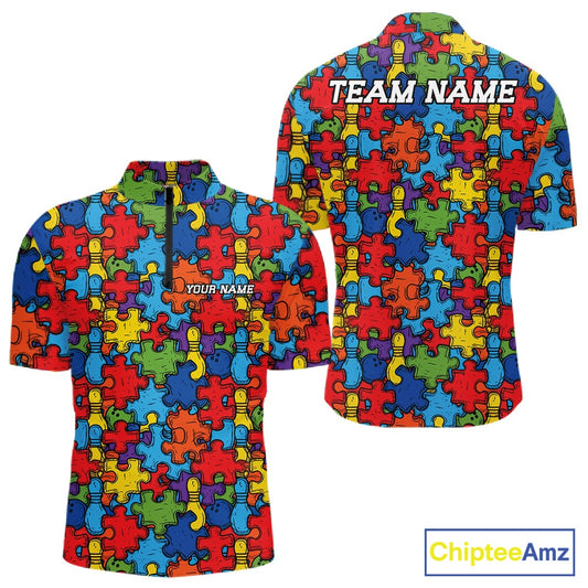 Front and back views of a short-sleeve quarter zip shirt featuring a colorful puzzle piece pattern in red, blue, yellow, and green. The front has a dark zipper at the collar and the text 'YOUR NAME' printed on the chest, while the back has 'TEAM NAME' printed across the shoulders.