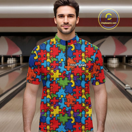 A man wearing a colorful short-sleeve bowling shirt with a puzzle-piece pattern in red, blue, yellow, green, and orange. The shirt has a mock neck and a white text placeholder reading 'YOUR NAME' on the chest.