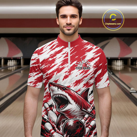 Man wearing a red and white shirt with a shark design in a bowling alley.