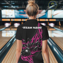 Load image into Gallery viewer, Female model back view in a bowling lane wearing a black polo shirt featuring a pink flaming black bowling ball striking pins in a vivid sports illustration.