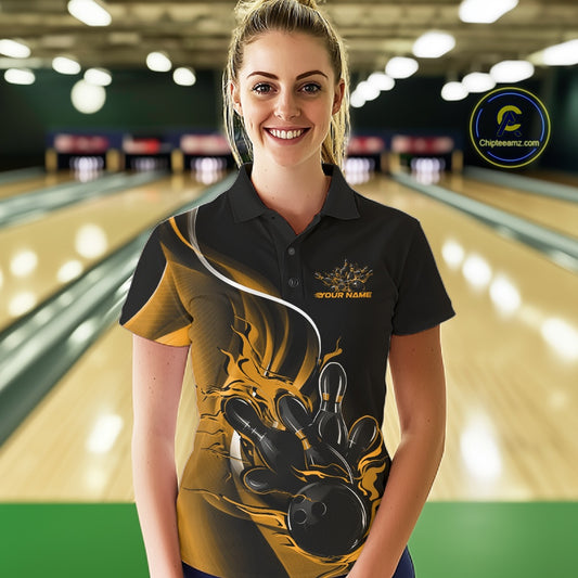 Female model front view in bowling lane wearing black and yellow polo shirt with flaming bowling ball hitting pins in energetic action design.