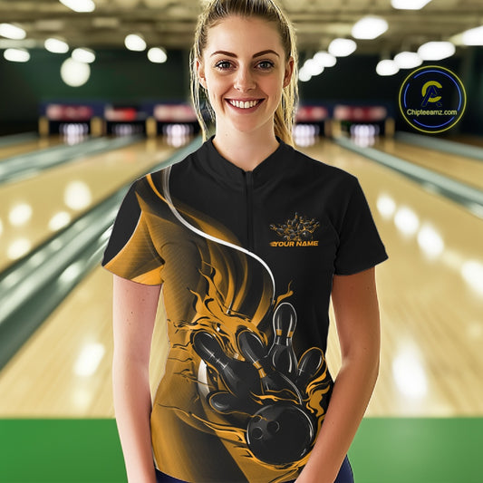 Front view female model in bowling alley wearing black and yellow quarter zip shirt featuring flaming bowling ball striking pins dynamic artwork