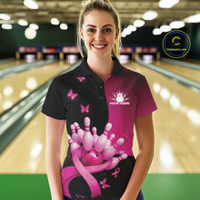 Load image into Gallery viewer, Female model in a bowling lane wearing a black and pink polo shirt with breast cancer awareness ribbons, butterflies, and bowling-themed artwork.