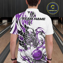 Load image into Gallery viewer, Back view of a male model wearing a white bowling polo with purple and black tribal scale artwork and a glossy red bowling ball striking pins at the bowling lane