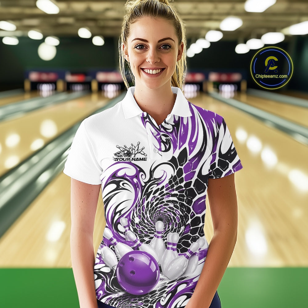 Female model in a bowling alley wearing a white bowling polo shirt with purple and black tribal accents, scale-inspired details, and a red bowling ball striking pins
