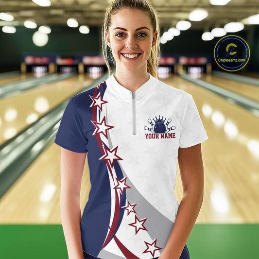 Female model front view at the bowling lane wearing a red, white, and blue bowling quarter zip shirt with bowling artwork and stars.