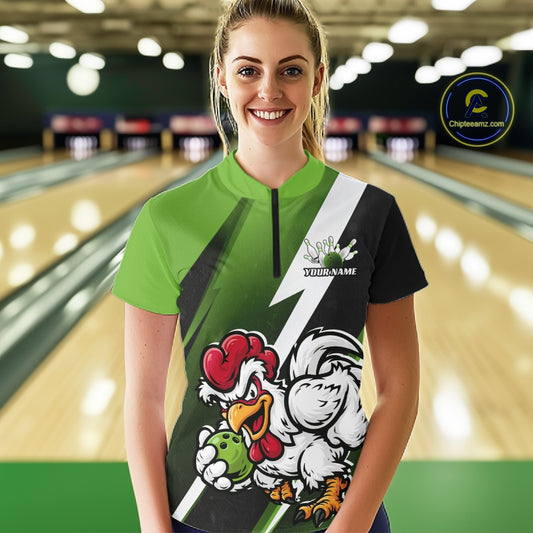 A woman standing in a bowling alley wearing a custom short-sleeve bowling t-shirt with a green, black, and white design featuring a cartoon rooster mascot and the text 'Your Name'.
